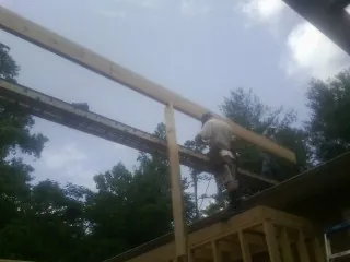Carpenter setting a ridge beam over a new addition frame — Ice Dam Removal by Roofing Brothers in Bolinas